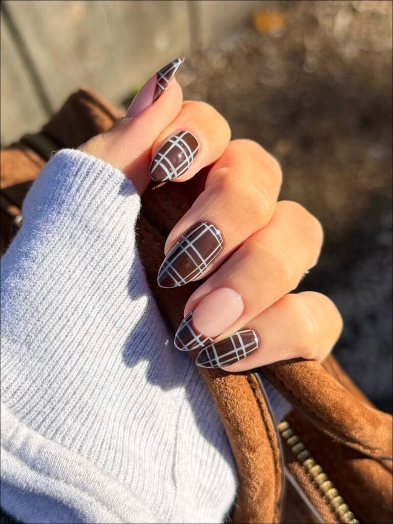 Long almond fall nail trends in chocolate brown with fine white plaid grid and one nude French accent