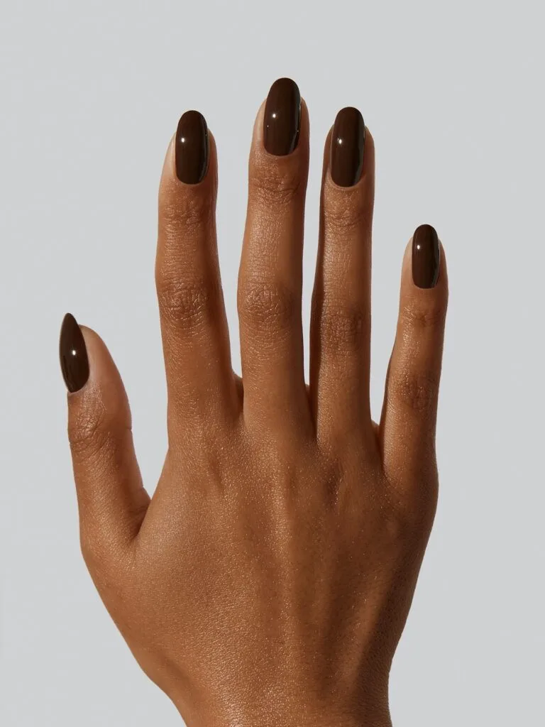 Deep espresso brown almond nails against a white background, an autumn nails idea.