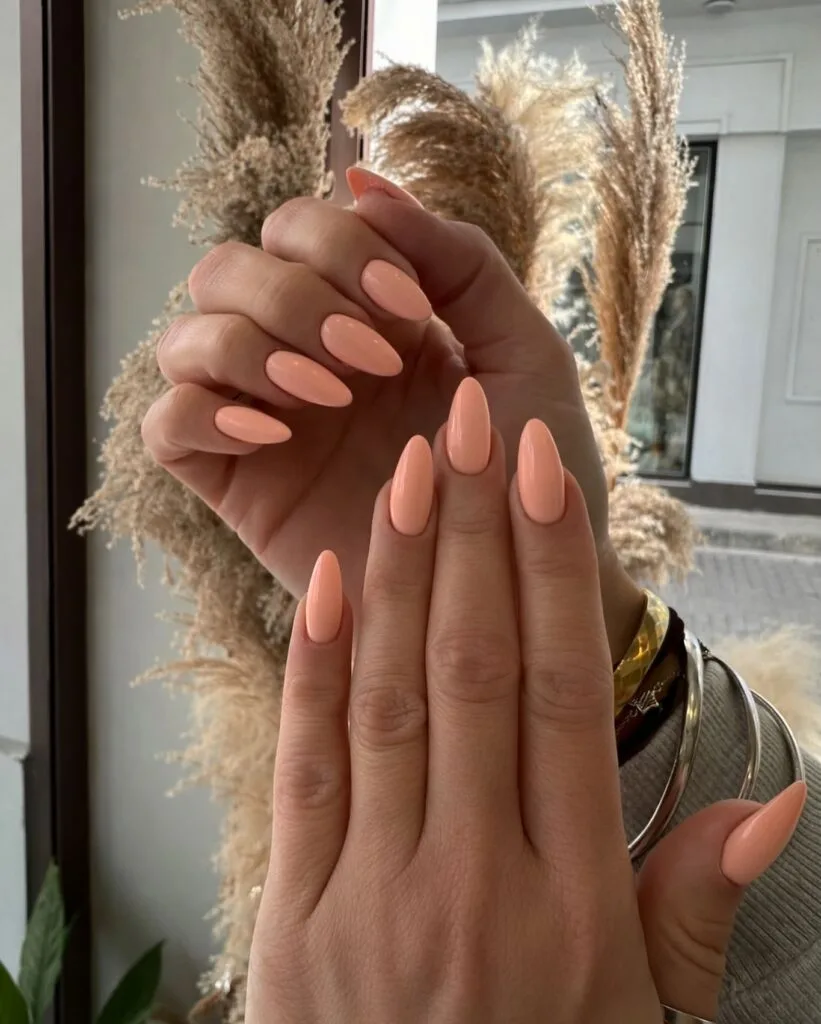 Long almond nails in creamy golden apricot with a glossy finish for early fall nails.