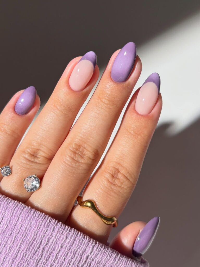 Lavender fall aura nails with pale pink bases, blurred purple French tips, and solid lilac accents.

