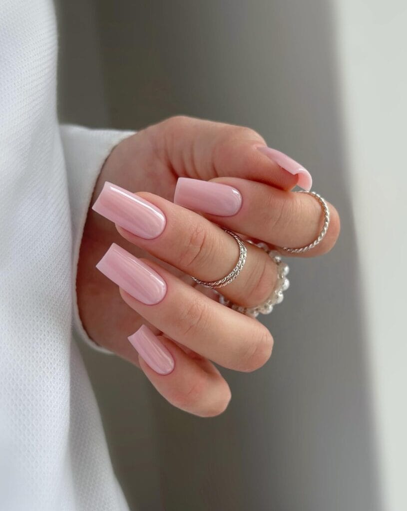 Long square nude nails in translucent pink with soft vertical pearly streaks.
