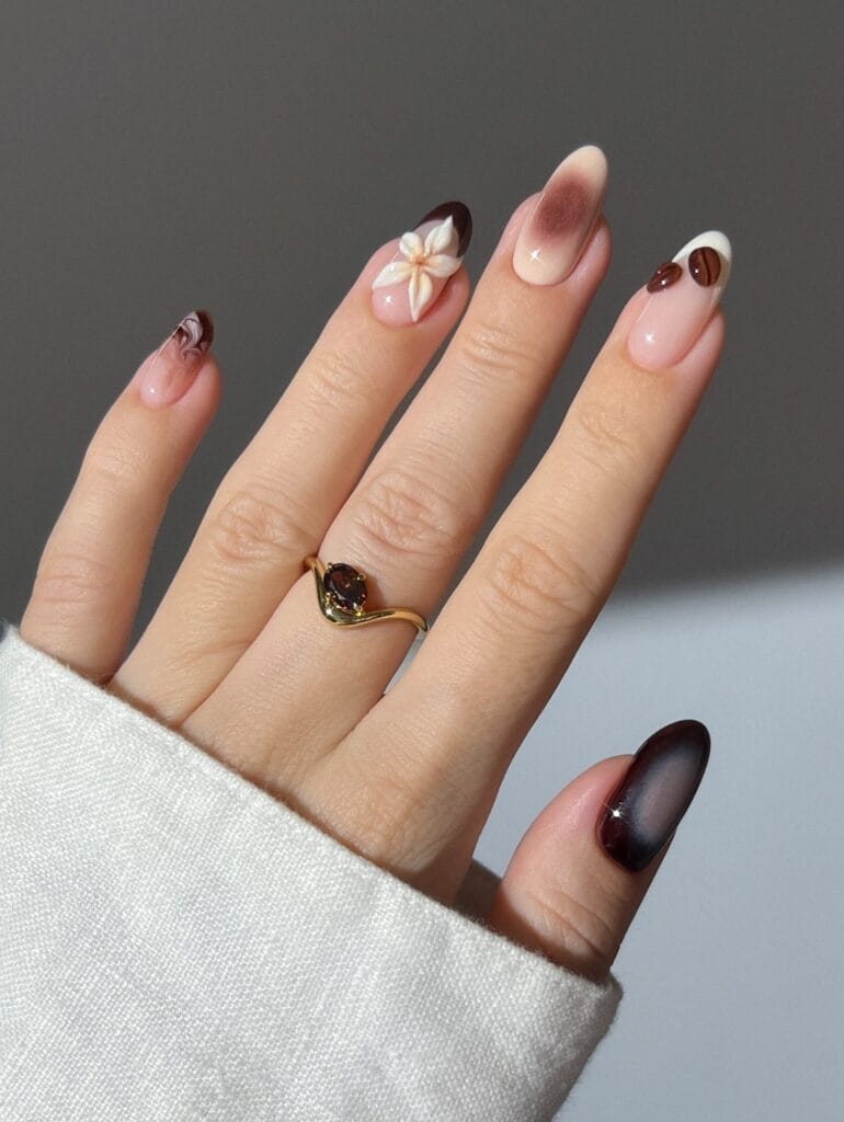 Neutral fall nails with mocha details, a 3D cream flower, and raised coffee-bean accents.