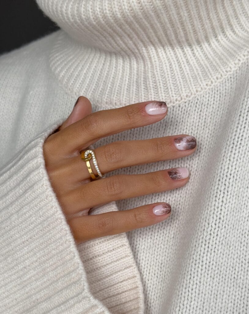 Short neutral fall nails with a milky base and smoky mocha marbling placed differently on each nail.