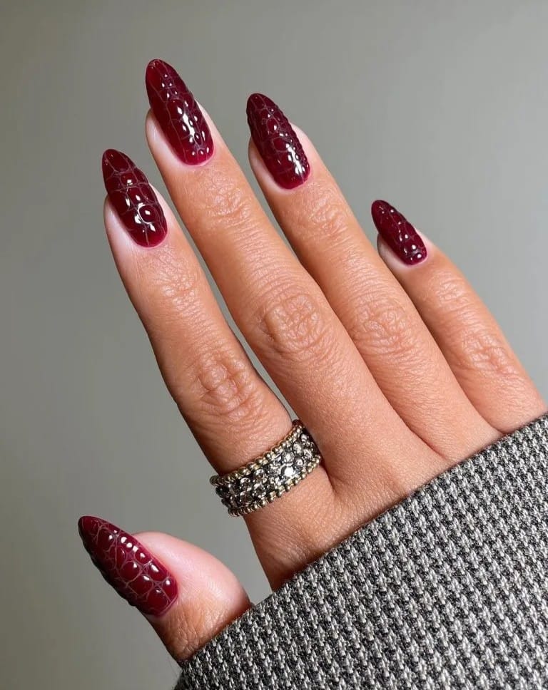 Almond September nails in dark cherry with raised crocodile texture and a glossy finish.