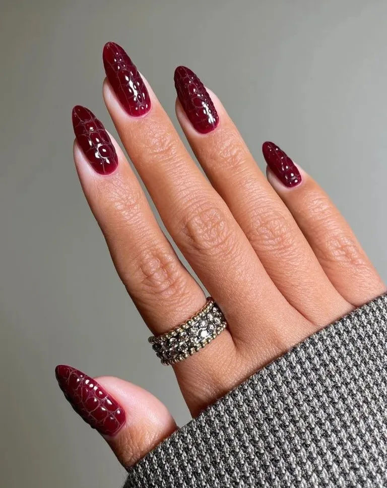 Almond September nails in dark cherry with raised crocodile texture and a glossy finish.