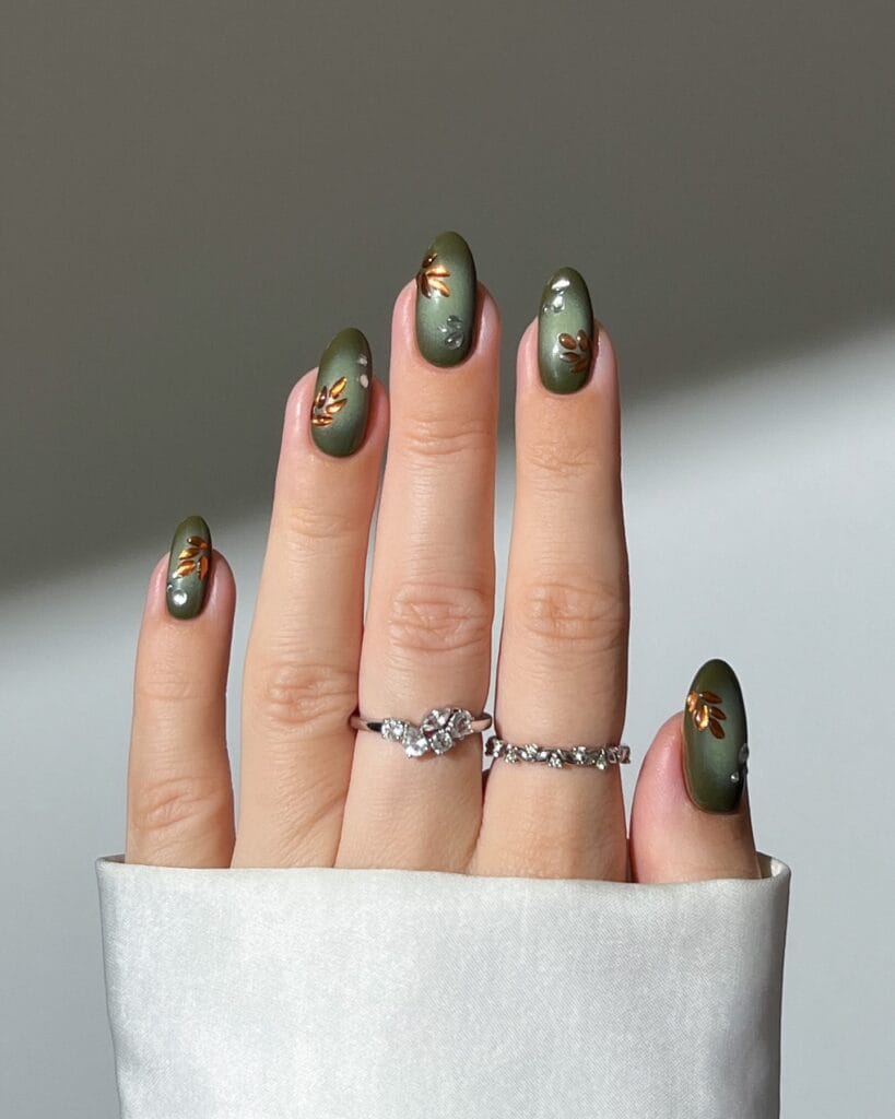 Olive fall aura nails with darker edges, copper leaf accents, and tiny clear droplets.
