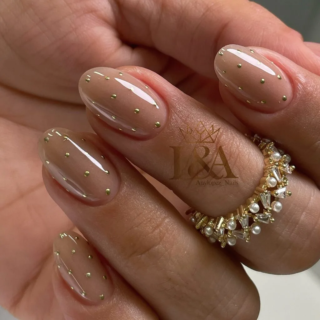 Sheer nude oval nails with scattered gold dots