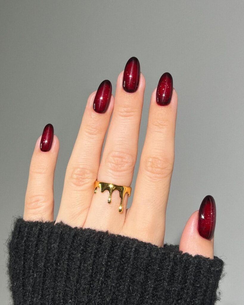 Garnet autumn 2026 nails with deep red aura shading, fine sparkle, and a glossy finish.
