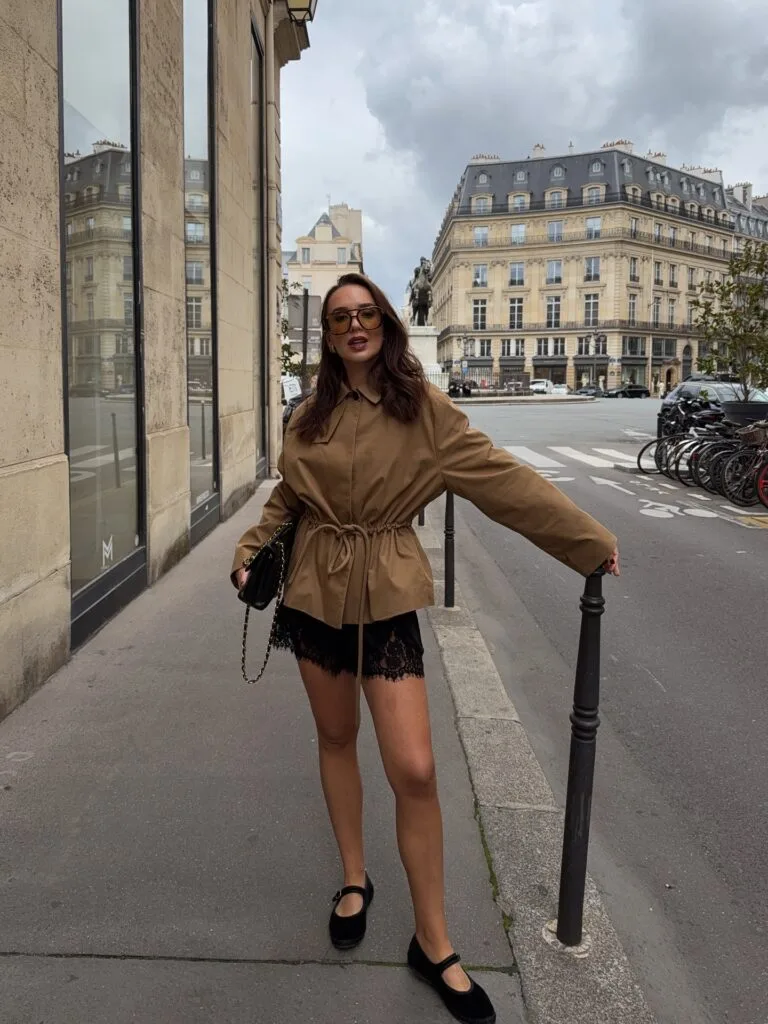 Early fall outfit idea with brown drawstring jacket, black lace shorts, and black Mary Jane flats.