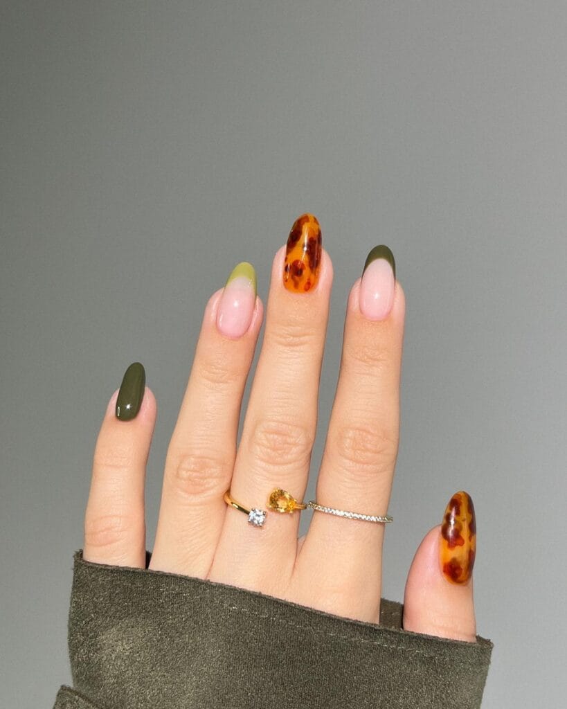 Tortoise nails mixed with glossy olive green, green French tips and amber tortoiseshell accents.

