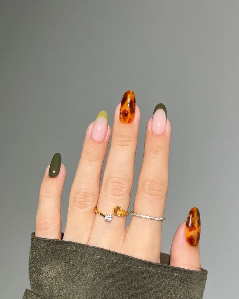 Tortoise nails mixed with glossy olive green, green French tips and amber tortoiseshell accents.
