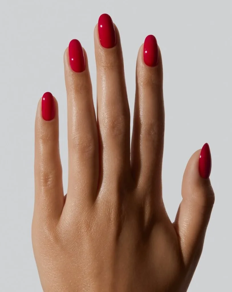 Glossy deep tomato red nails on a long oval shape, a warm fall nail colors look.