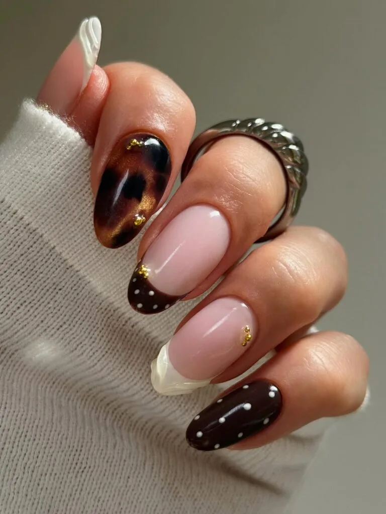 Tortoise nails with milky pink, chocolate tips, white dots, gold studs and tortoiseshell accents.
