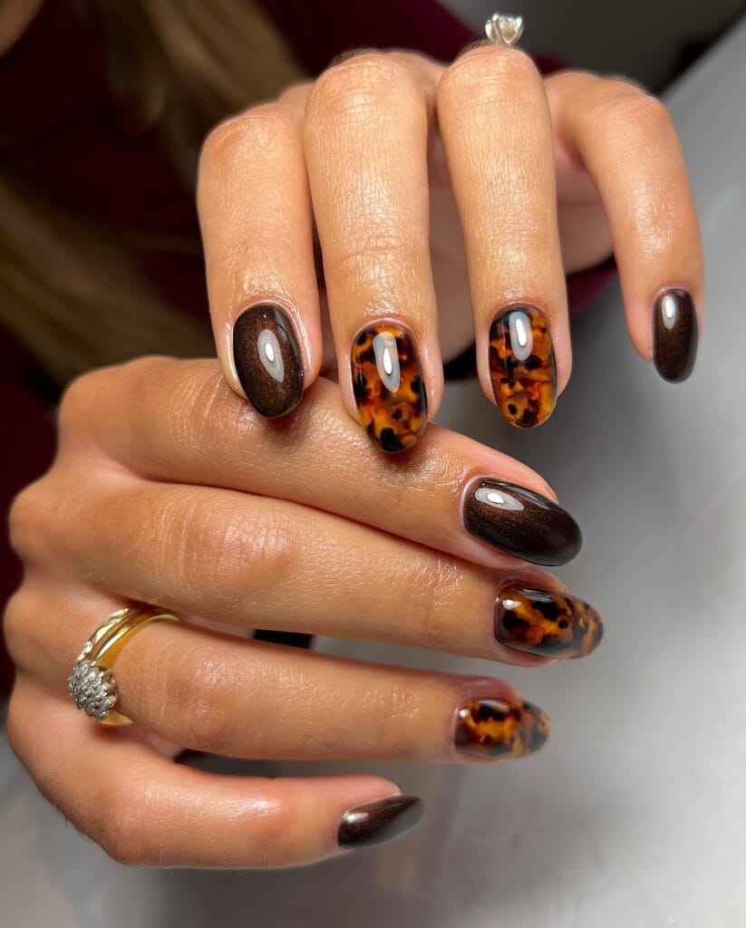 Short oval fall 2026 nails in amber tortoiseshell alternating with glossy dark espresso brown