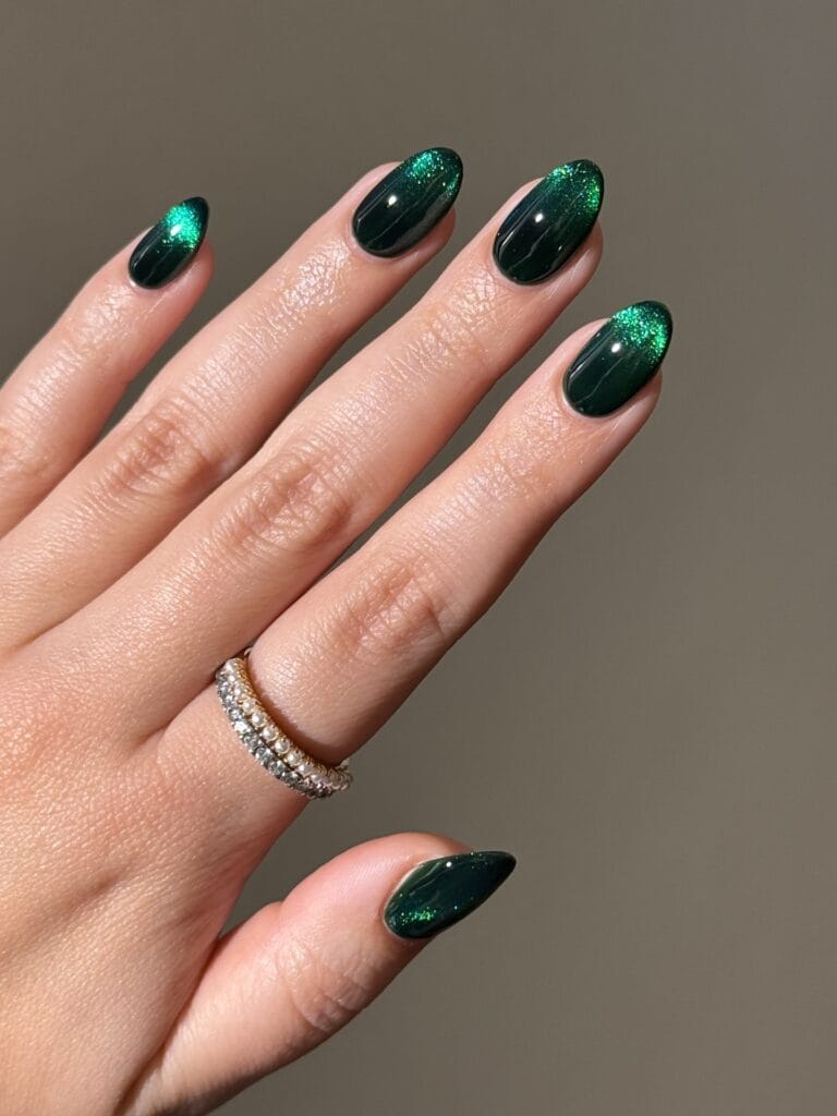 Deep forest green almond nails with emerald magnetic shimmer, an autumn nails look.