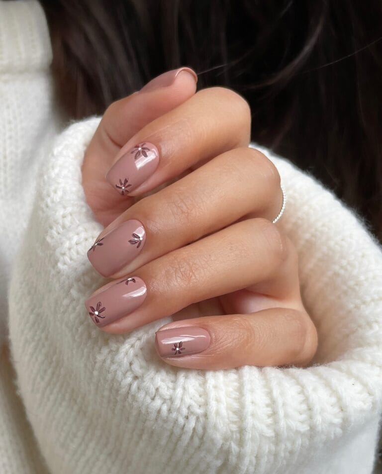 Glossy mauve nude square nails with tiny brown floral accents.