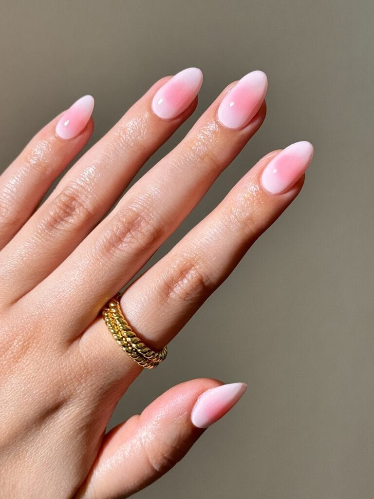 Milky blush nude almond nails with a soft pink center and glossy finish for September nails.