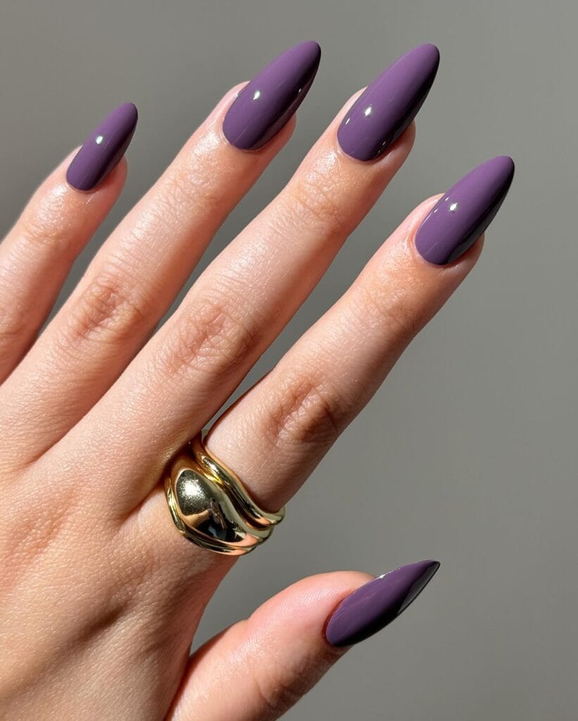 Glossy smoky amethyst almond nails in muted gray-purple, an autumn nails look.