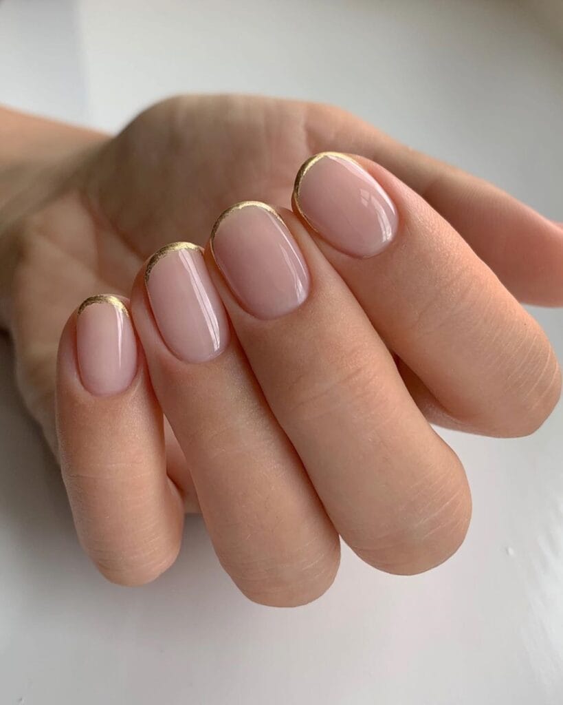 Short round 2026 autumn nails in sheer nude with a fine gold foil micro French tip