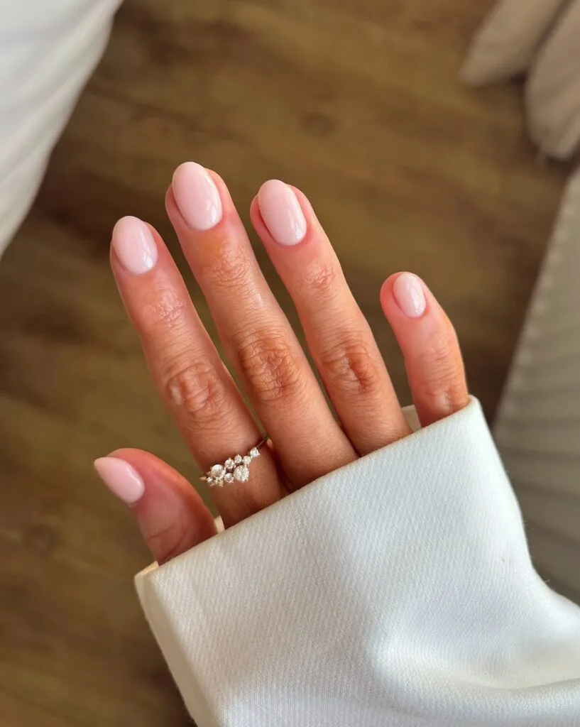 Glossy milky blush nude nails on short ovals with a sheer pink finish for autumn nails.