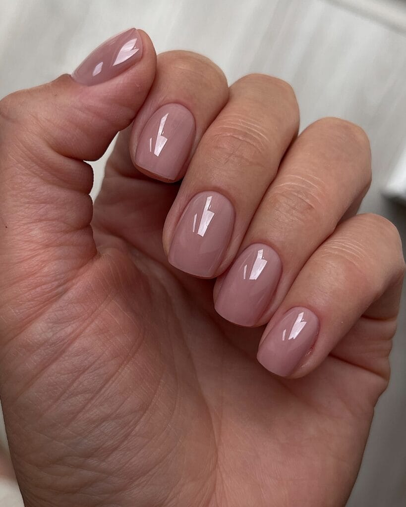 Glossy mauve nude nails with a glass lacquer finish, a simple early fall nails look.