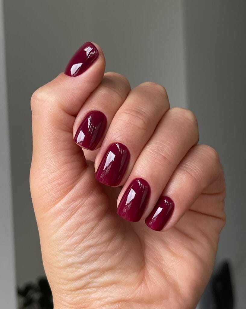 Deep berry nails with a high-gloss glass lacquer finish for autumn nail colors.