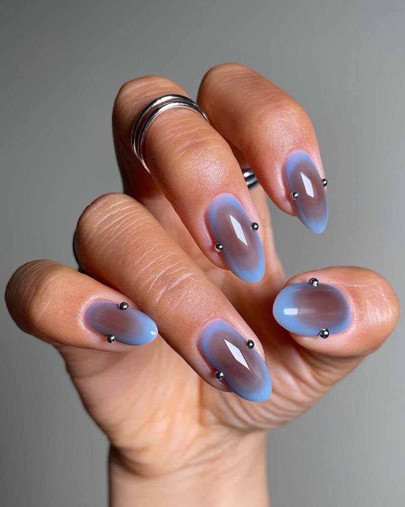 Long almond fall 2026 nails in blue aura over milky brown with tiny silver bead accents
