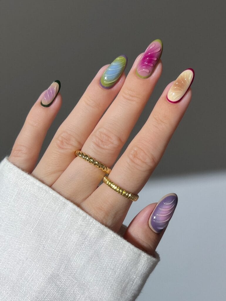 Colorful fall aura nails with blue, pink, green, lilac and cream fades plus raised ripple art.
