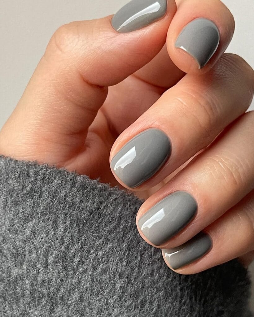 Short glossy oyster gray nails in a creamy cool gray shade, fall nail colors.
