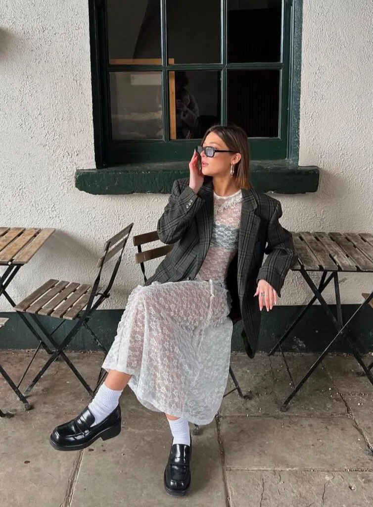 White lace dress under an oversized plaid blazer with loafers in a fall 2026 outfit.