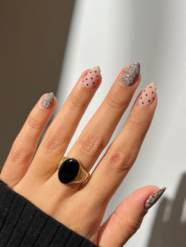 Short almond autumn nails 2026 mixing matte black polka dots with gold flecked tweed accents