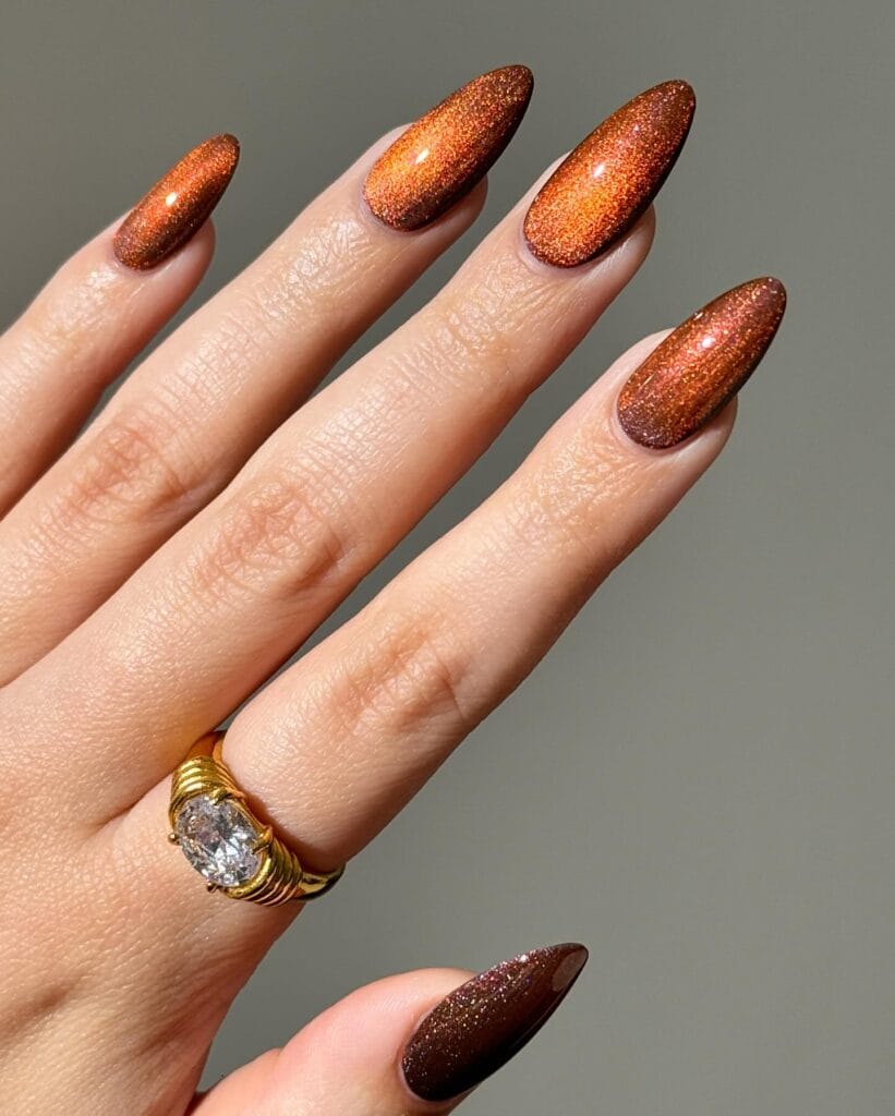 Copper almond nails with fine metallic shimmer and a dark brown base, fall nails inspiration.