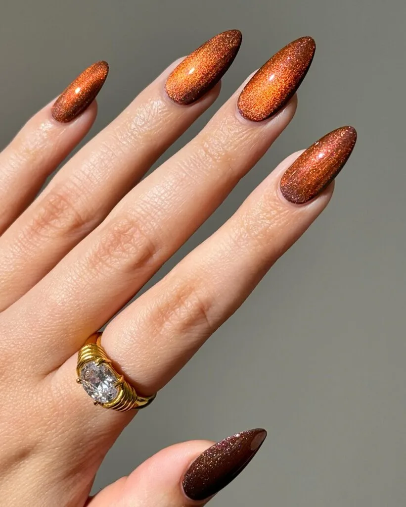 Copper almond nails with fine metallic shimmer and a dark brown base, fall nails inspiration.