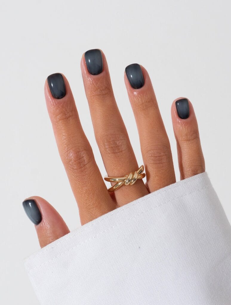 Short charcoal autumn nails with soft grey aura centers and a glossy square finish.
