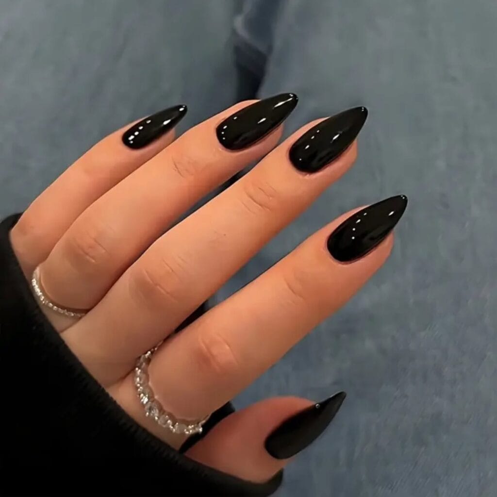 Long almond patent black nails with a mirror-like glossy finish, fall nail colors.