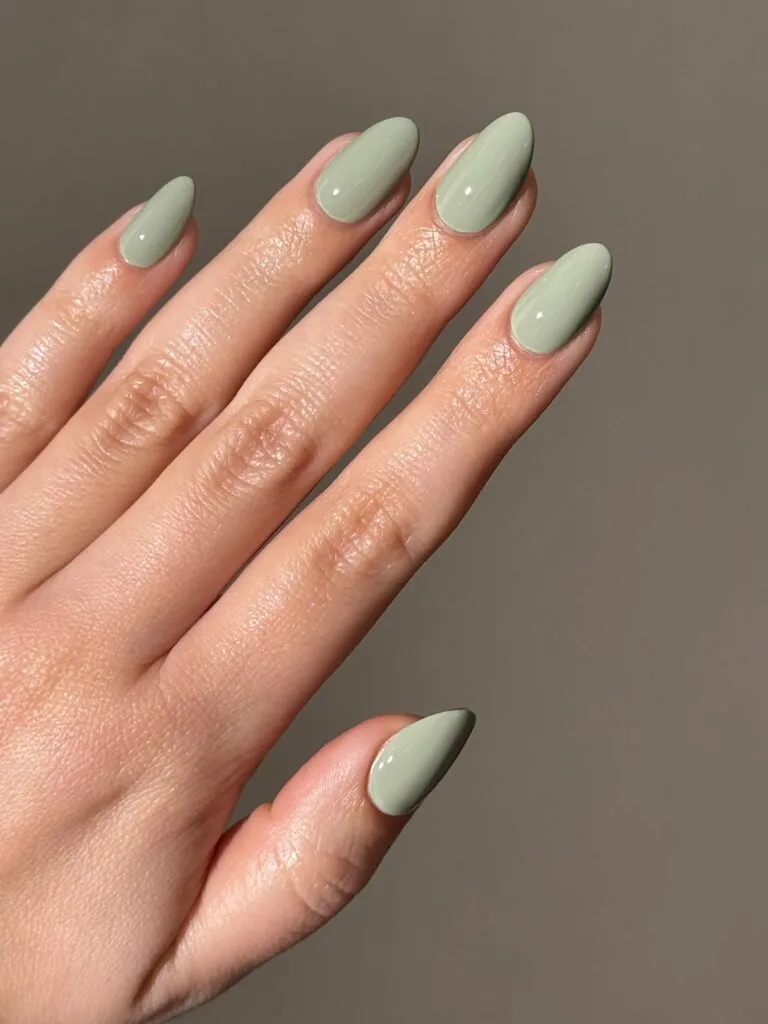 Almond glossy sage green nails in a soft muted shade, an autumn nail colors idea.