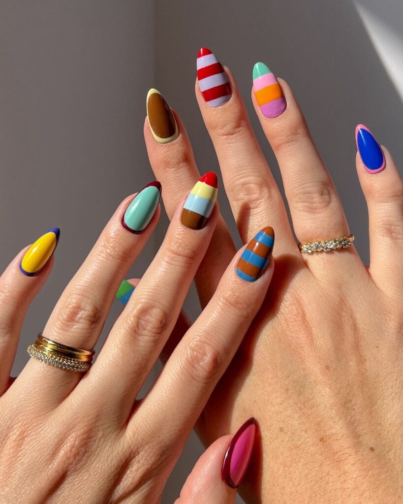 Almond fall 2026 nails mixing bright stripes and color blocks in red, lilac, blue and orange