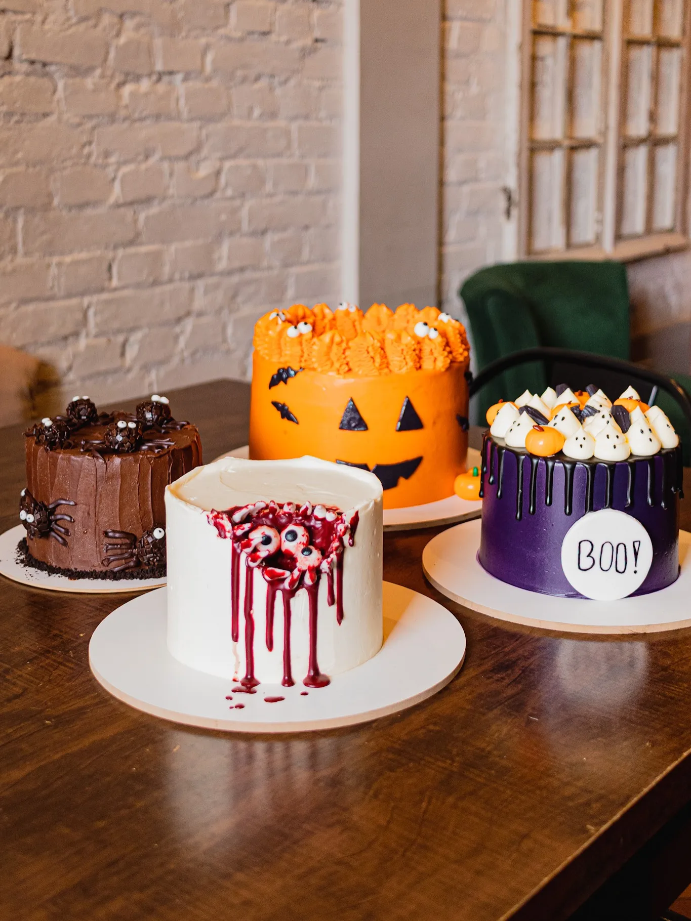 Halloween party cakes with spider, pumpkin, bloody-eye, and purple "BOO!" designs
