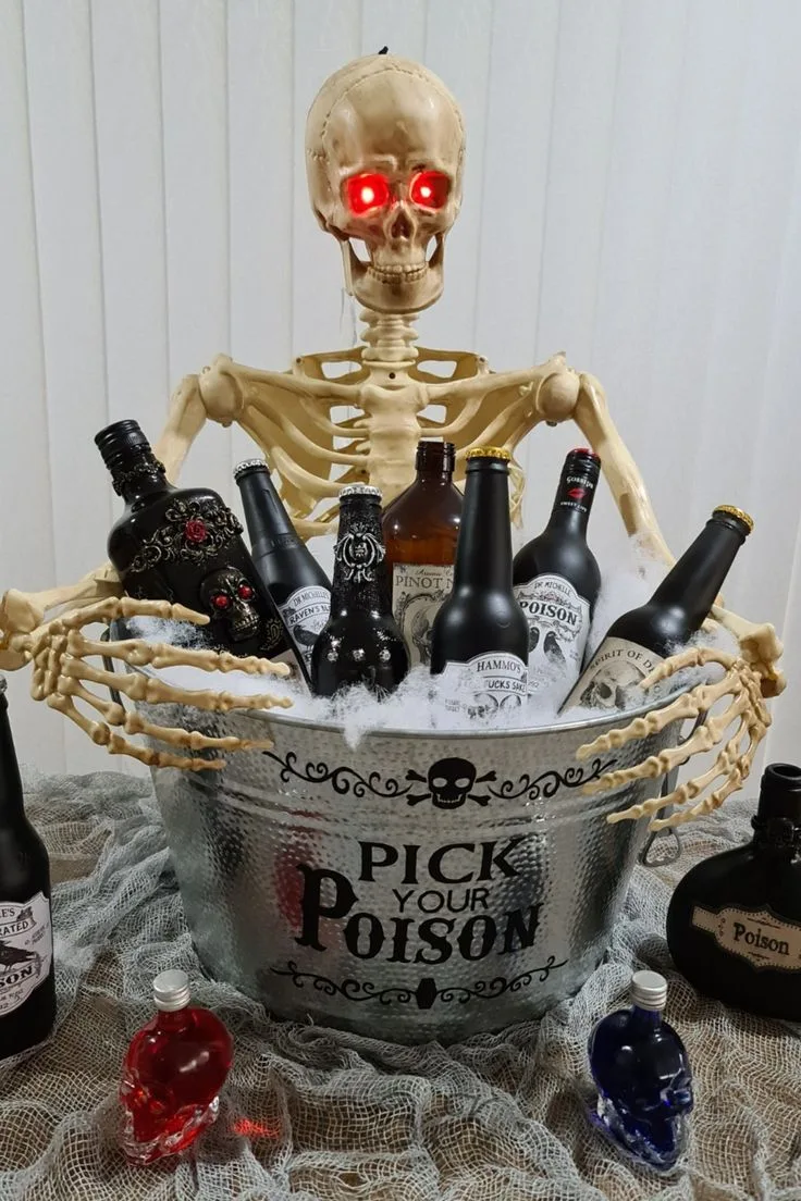 Halloween drink tub with skeleton hands, black bottles, cobwebs, and "Pick Your Poison" text
