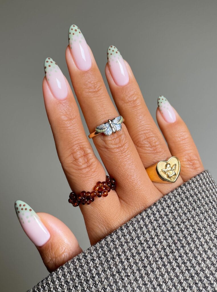 Almond autumn nails with pink bases, mint green French tips, brown dots, and mint dots below the tips.
