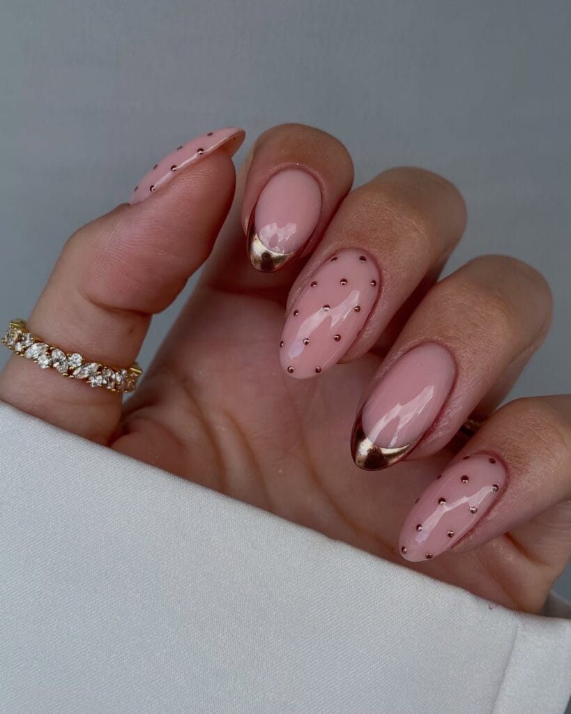 Pink almond fall polka dot nails with tiny rose-gold metallic dots and matching reflective French tips.
