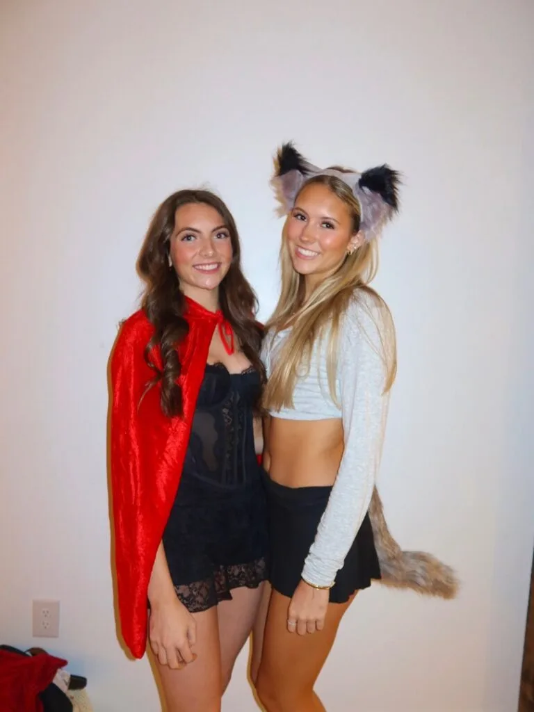 Red Riding Hood and wolf costumes for best friends, with a red cape, black lace dress, gray crop top, and furry ears.