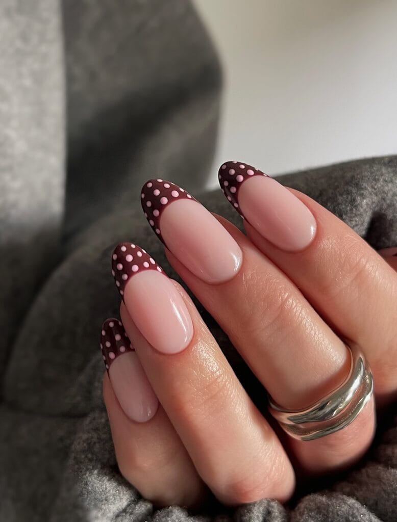 Fall polka dot nails with glossy pink almond bases and burgundy French tips covered in pale pink dots.
