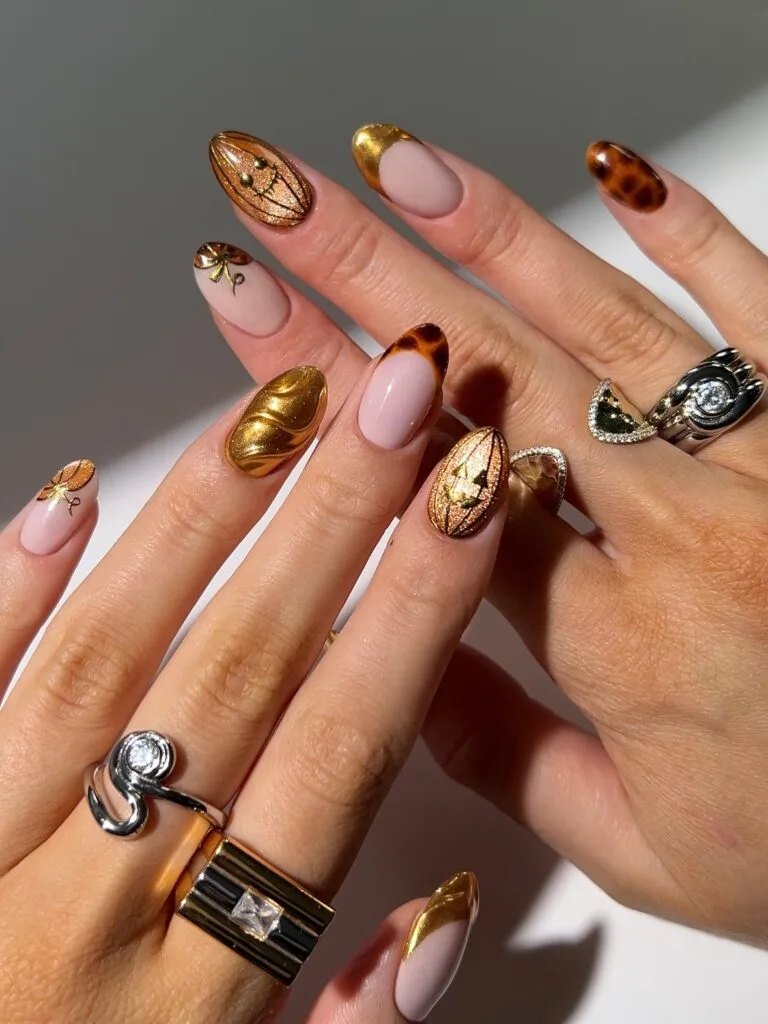 October nails with gold chrome, tortoiseshell accents, nude bases, and amber nail art.
