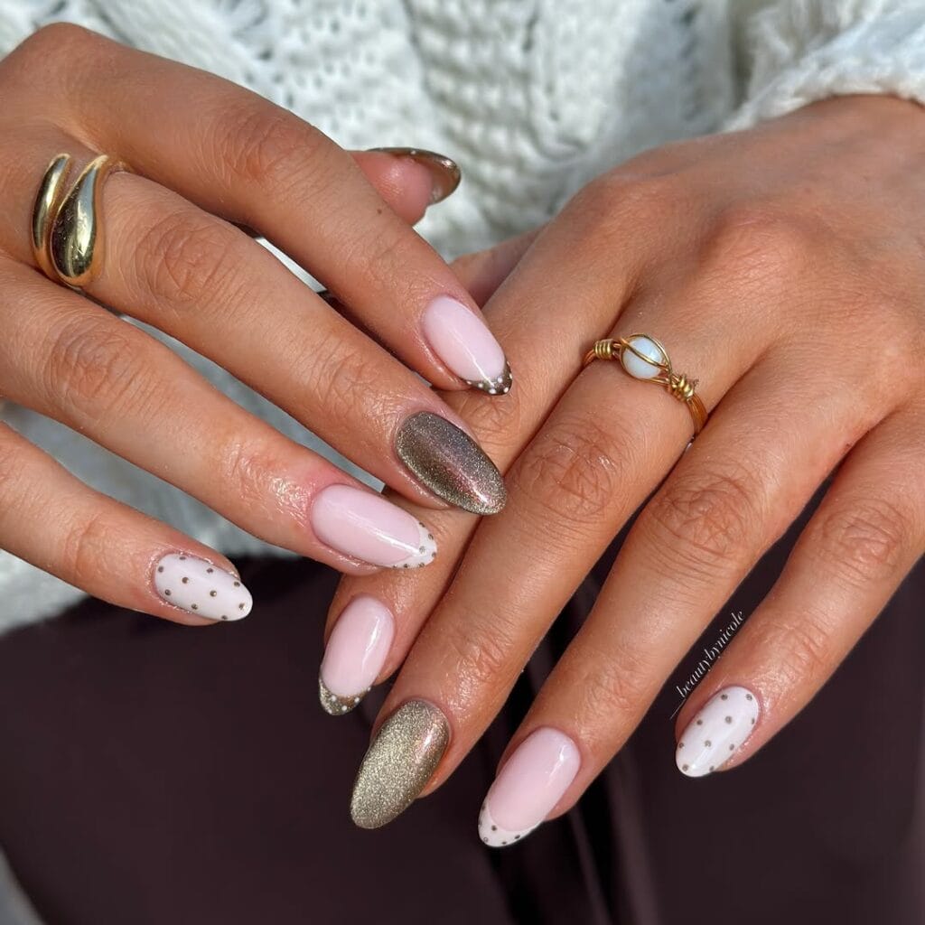 Almond autumn nails with dotted white and taupe French tips, metallic dots on white accents, and velvety taupe shimmer.