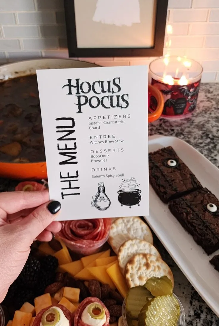 Halloween party menu card titled "Hocus Pocus" above a charcuterie spread and brownies