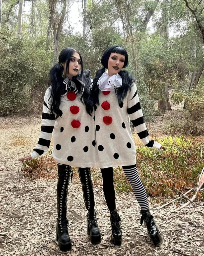 Best friend clown costumes with white polka-dot sweater dresses, striped sleeves, red pom-poms, and black lipstick.