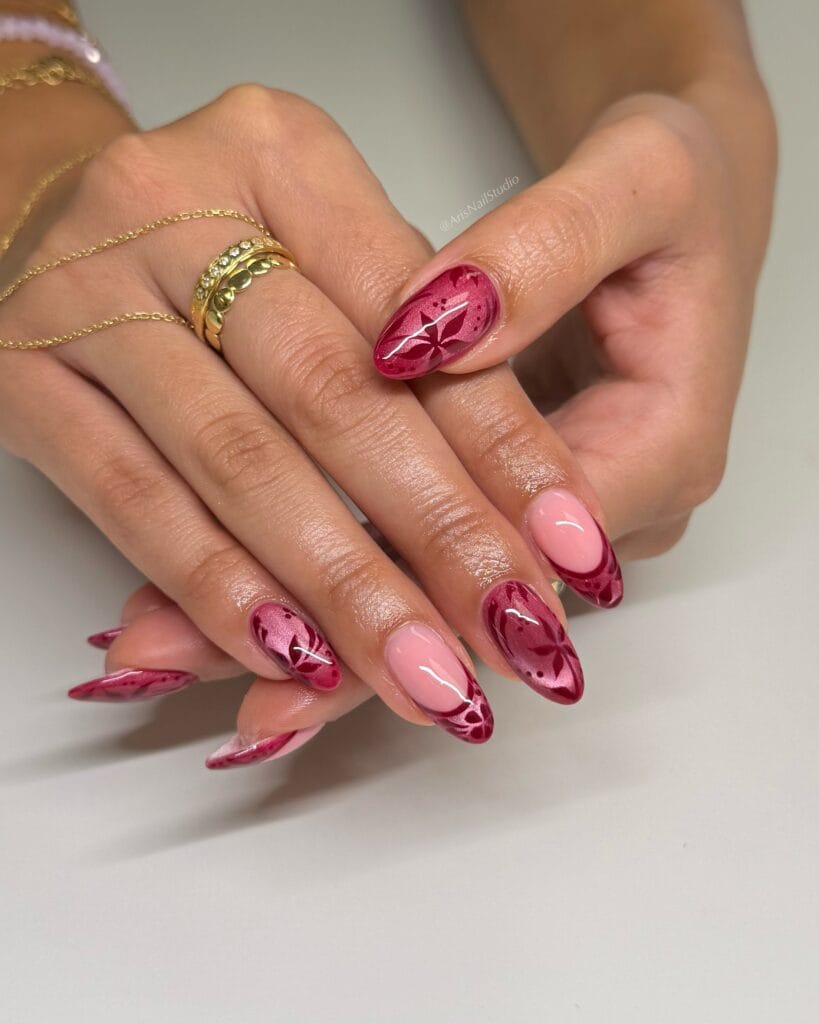 Berry pink autumn nails with velvet shine, dark floral art, and glossy almond shapes.
