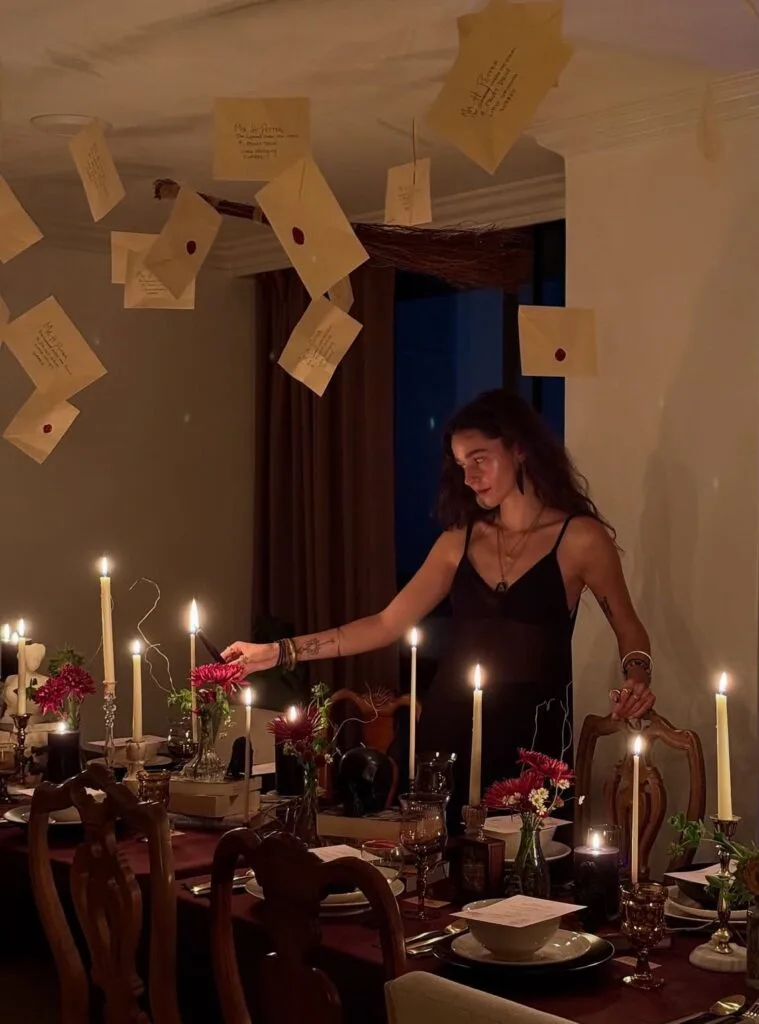 Halloween ceiling decor with floating envelopes above a candlelit dining table
