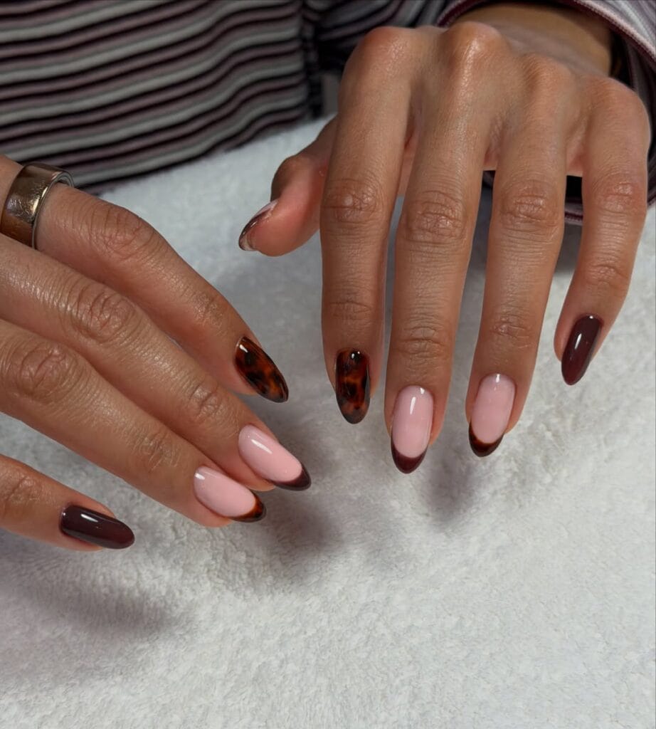Autumn nails with tortoiseshell accents, dark brown polish, and glossy mocha French tips.
